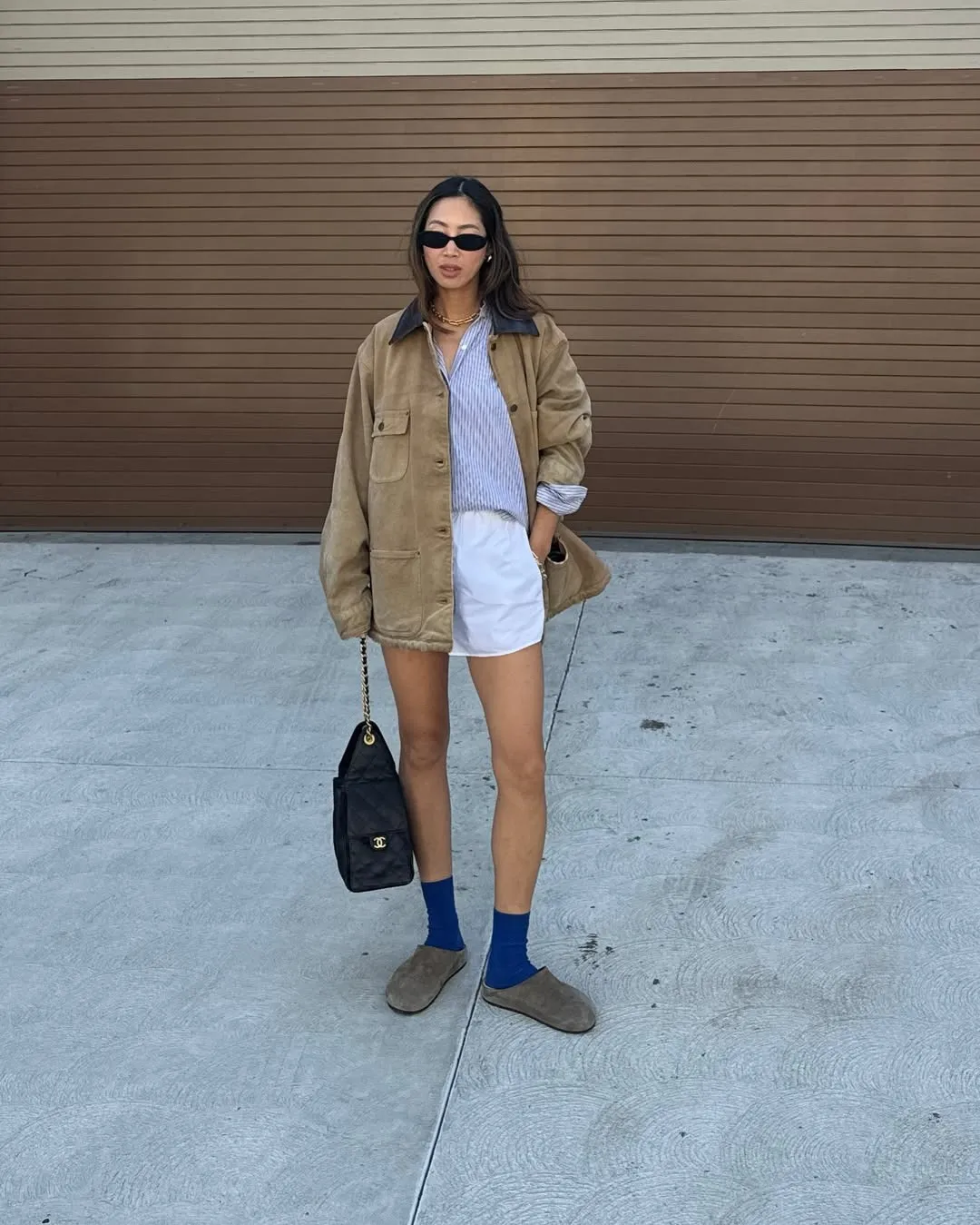 Woman in barn jacket, shorts, and slipper mules