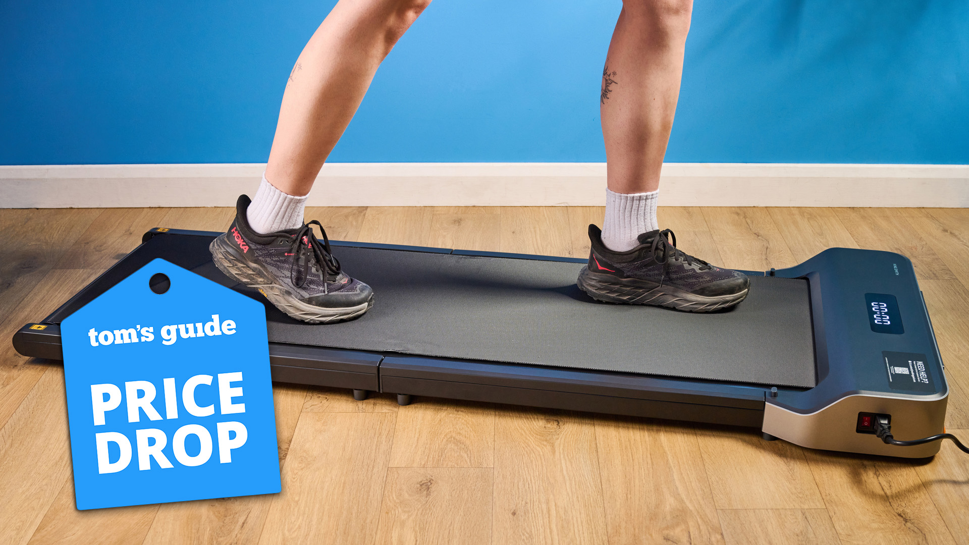 The WalkingPad Z1 foldable treadmill with a woman walking on it in Hoka running shoes and a price drop tag.