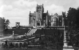 A black and white photo of Ardross Castle, a 19th century Gothic style Scottish manor house with a large formal garden laid out in Ardross, Scotland. Taken in 1960.