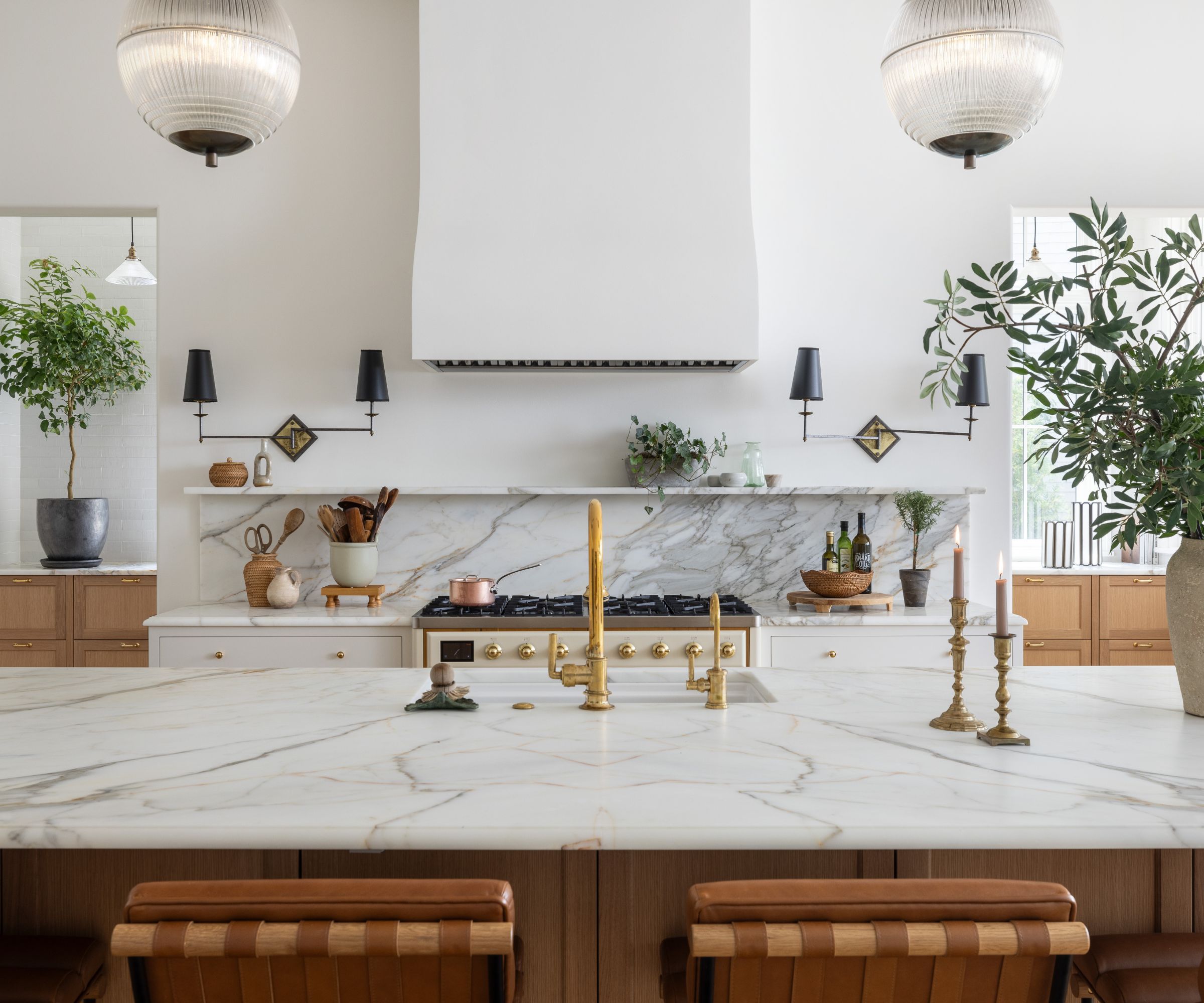 A neutral kitchen with marble countertops and a wooden island