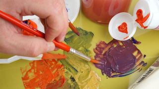 Acrylic paint being mixed on a palette with a brush