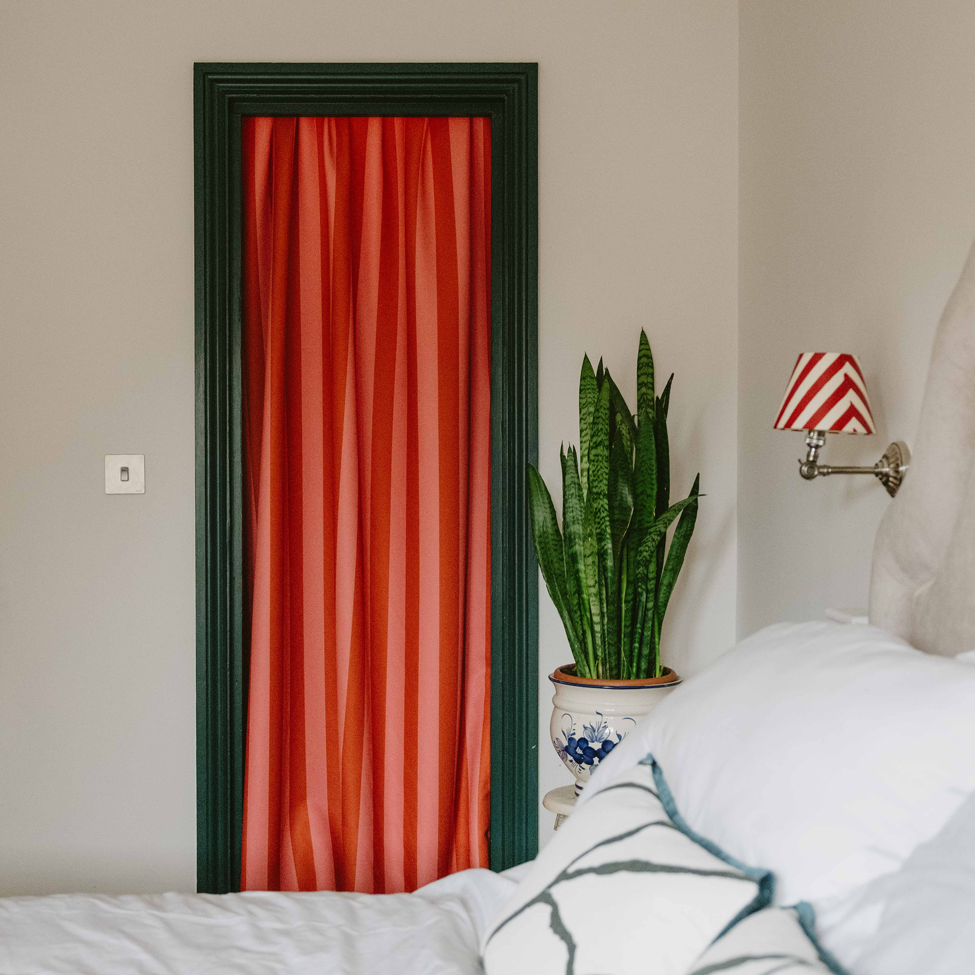 red striped curtain in doorway with green frame in neutral bedroom