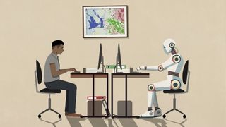A human and robot sitting opposite each other working at computers in an office environment