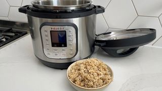 Instant Pot Duo Nova next to a bowl of rice cooked in the multi-cooker
