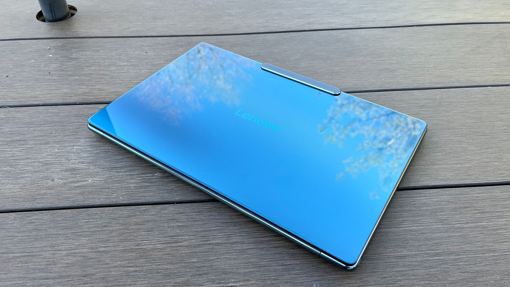 A Lenovo Yoga Slim 9i sitting on a picnic table outside