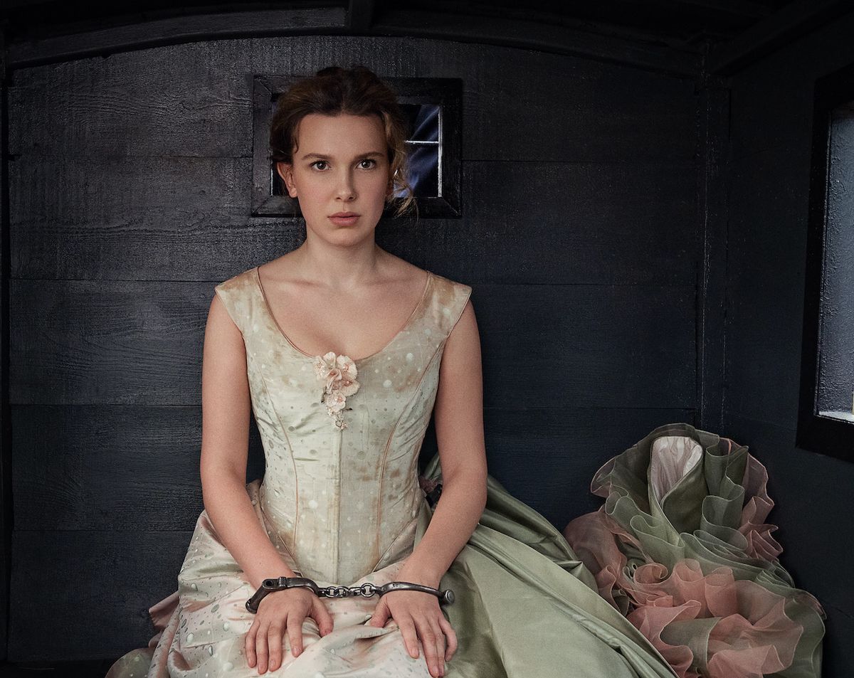 Millie Bobby Brown in white dress and handcuffed in Enola Holmes 2