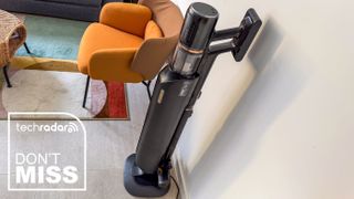 Dreame Z50 Station stick vacuum beside a chair with a TechRadar Don't Miss deals badge
