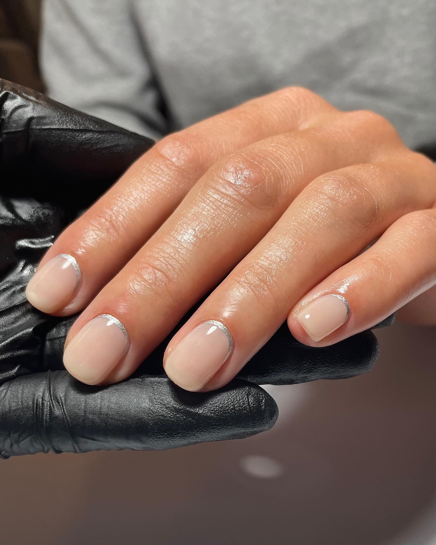 A picture of a silver reverse French manicure