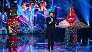 Star and Cracker on stage with Joel Dommett in The Masked Singer Christmas special 2024