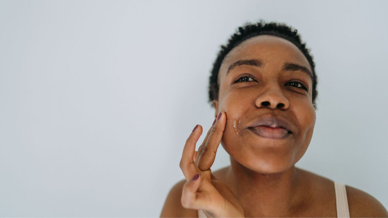 A woman applying one of the best spot treatments to her face