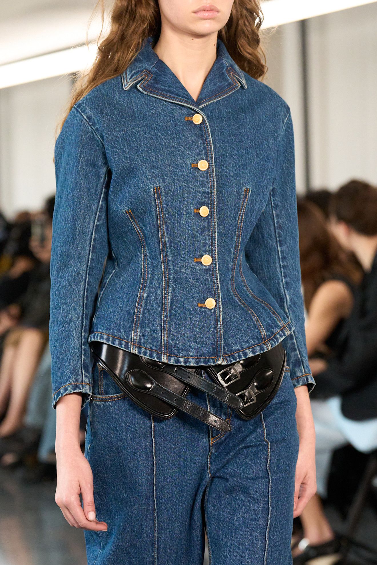 Woman in structured denim jacket.