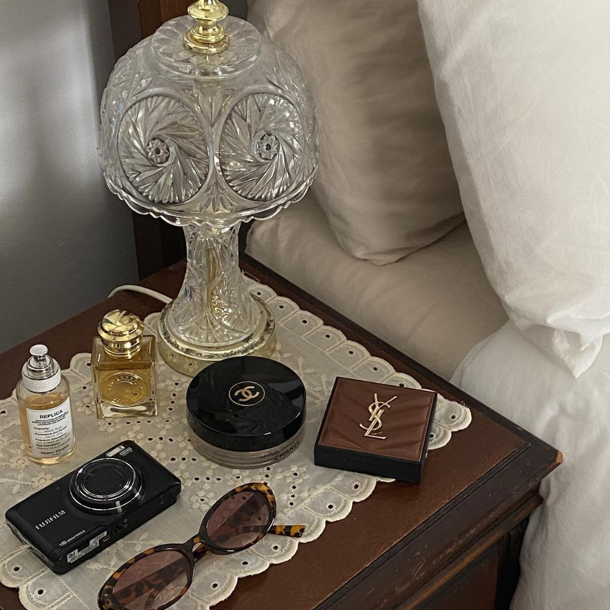 A chic bedside table with a Burberry and Maison Margiela Replica perfume on