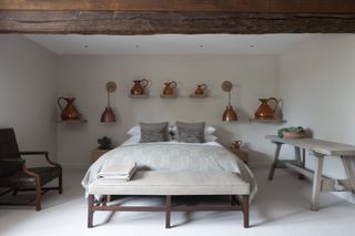 Bedroom with brass fixtures and pots, grey wooden table