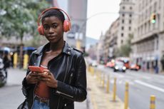 Sex apps: A woman wearing headphones stands on her phone