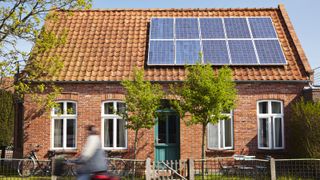 small red brick house with solar panels on roof