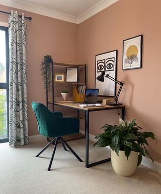 A desk in a room with plant and curtains