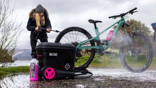 Muc-Off portable pressure washer in action on MTB