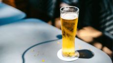 Cold glass of beer sitting on a metal table, representing one of the low-calorie beer options