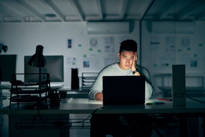 Young businessman looks stressed late at night in the office.