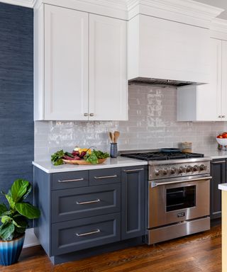 Kitchen with blue floor cabinets and whie wall cabinets and white tile backsplash