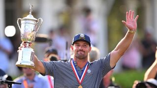 Bryson DeChambeau holds up the US Open trophy to the fans after his win