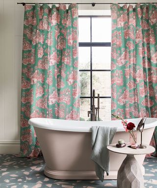 freestanding pink painted bath with toile curtains and terrazzo floor tiles