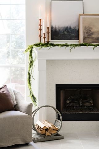 A winter living room with garland above fireplace