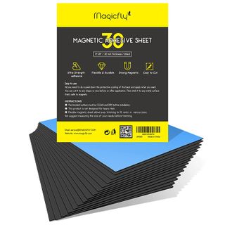 A pack of black magnetic adhesive strips on a white background