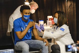 a teen gets the Pfizer COVID-19 vaccine in Michigan.