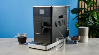 the kitchenaid kf3 superautomatic coffee machine photographed against a blue tom's guide background