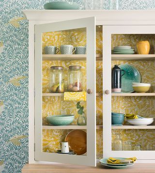 kitchen with leafy wallpaper and white cabinet