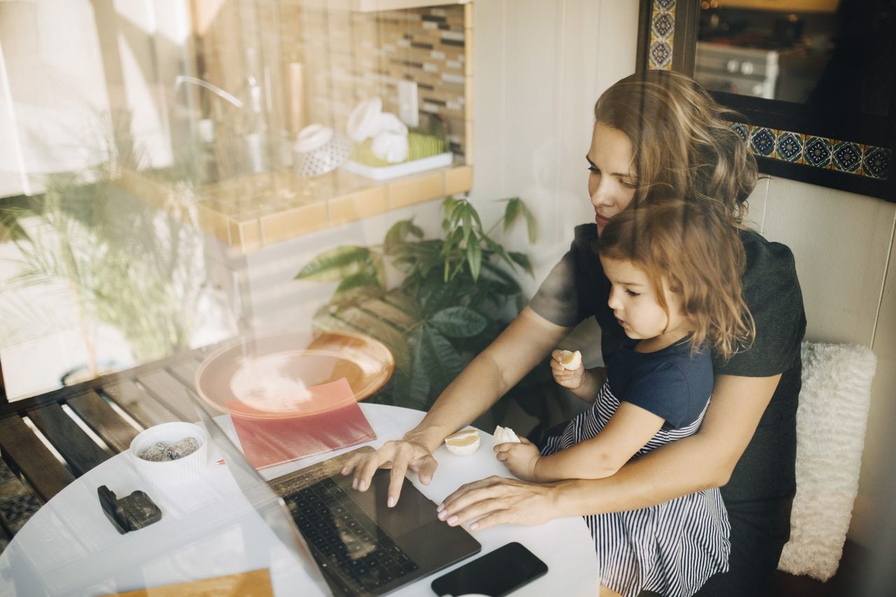 woman working from home during Christmas lockdown with daughter