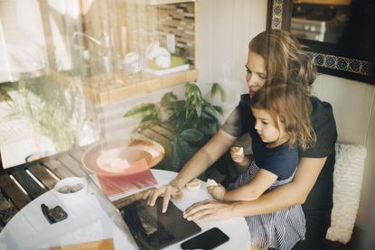 woman working from home during Christmas lockdown with daughter