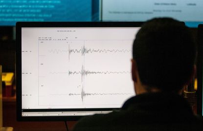A person looks at a seismograph.