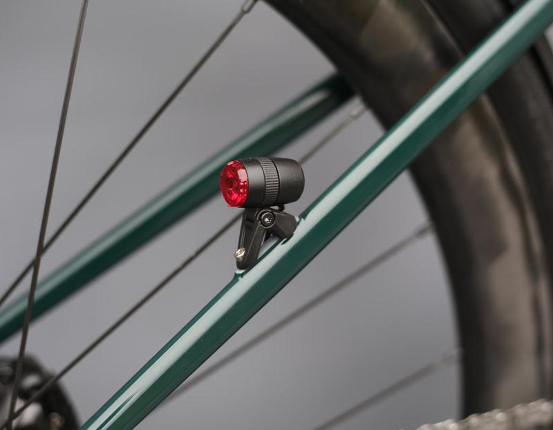 A rear bike light on a green frame