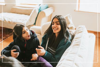 sisters talking and laughing on sofa