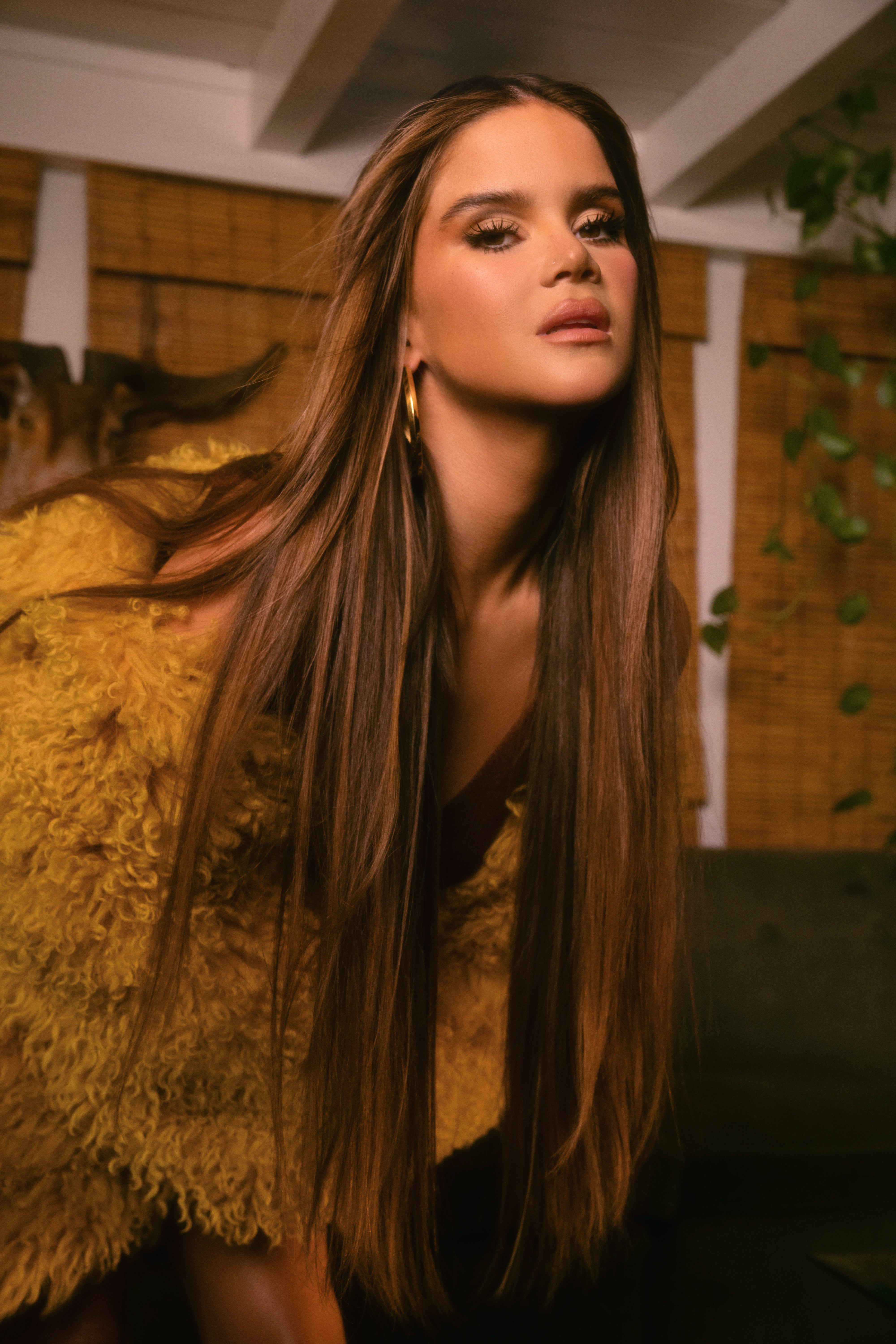 maren morris wears her brown hair down straight and poses in a yellow fur coat