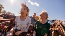 People smile and yell while on a roller coaster