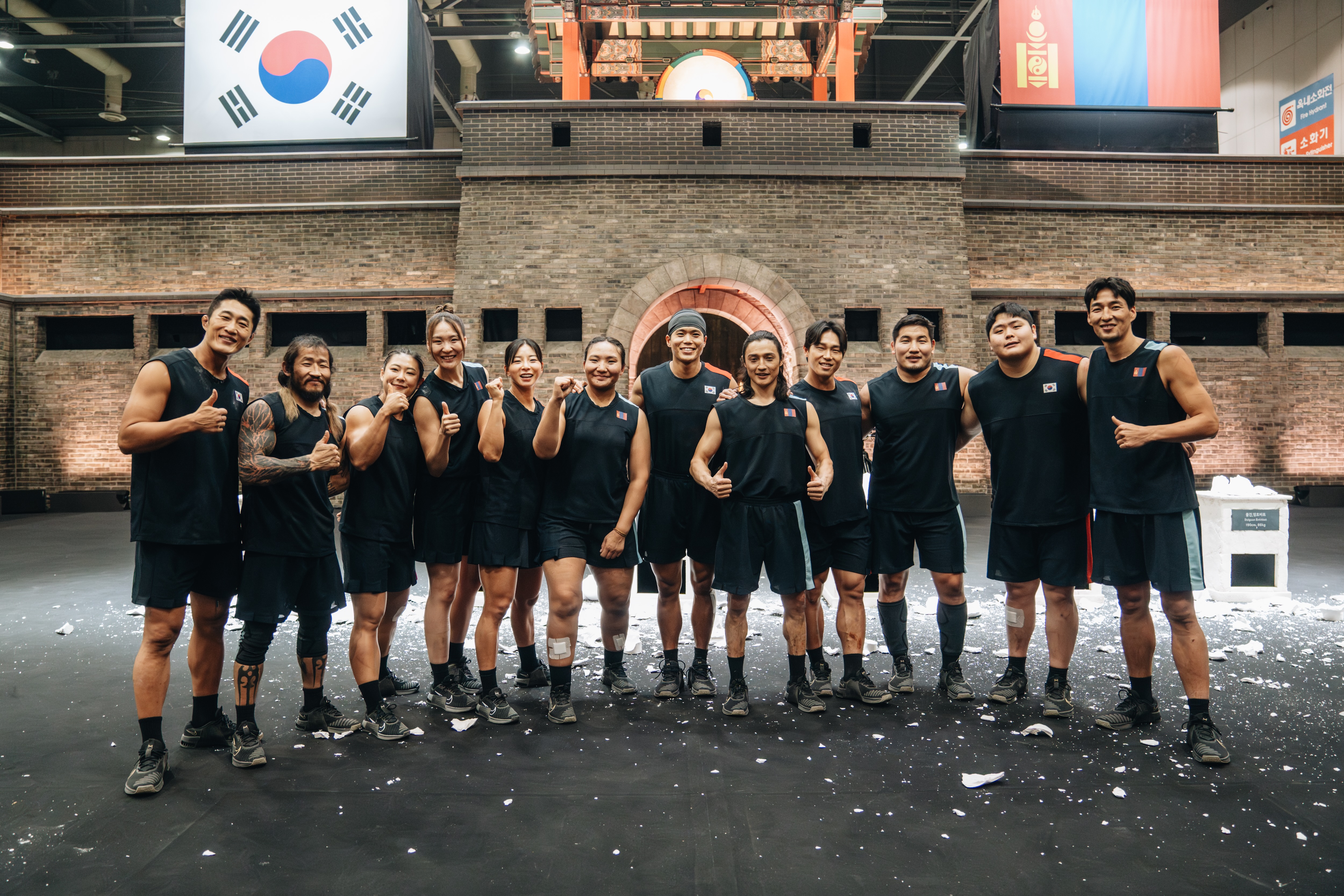 The Team Korea and Team Mongolia athletes (l-r Kim Dong-hyun, Enkh-Orgil Baatarkhuu, Choi Seung-yeon, Khandsuren Gantogtokh, Jang Eun-sil, Adiyasuren Amarsaikhan, TK) pose for a group photo, in Netflix&#039;s &#039;Physical: Asia.&#039;