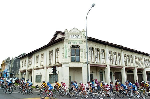 The peloton corner around some older Malaysian architecture nearing the final forty kilometres of the stage.