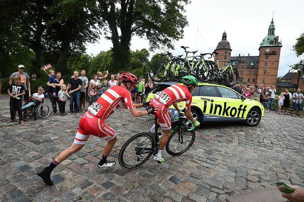 Team Postnord Danmark teammates helping each other during a mechanical