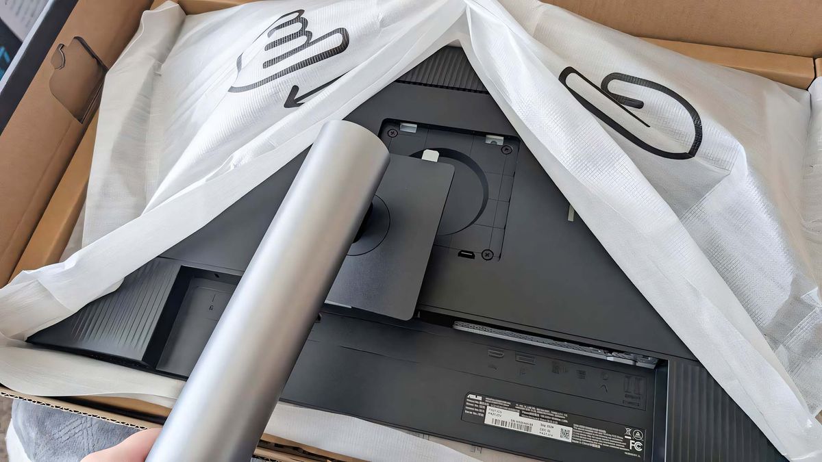 The ASUS ProArt PA27JCV's stand about to get pressed into the back of the monitor during assembly.