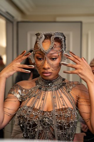 Megan Thee Stallion gets ready for the Gaurav Gupta haute couture show in Paris wearing a chainmail bodysuit and headpiece