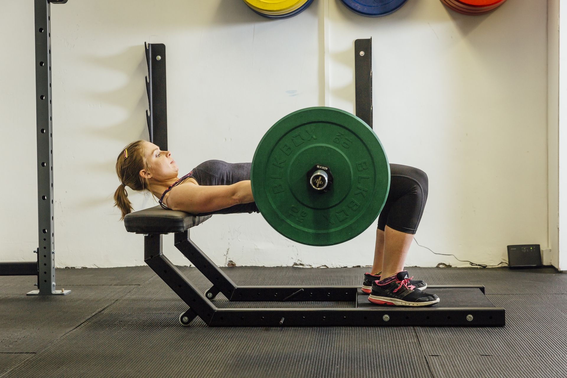 Hip thrust exercise in gym with bar bell