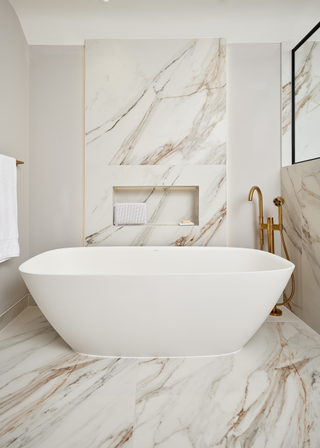 freestanding tub in a marble clad bathroom