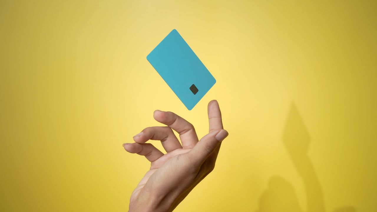 Close up male hand with credit card on yellow backdrop