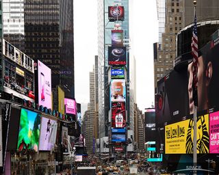 An image of two interacting galaxies known as Arp 273, captured by the Hubble Space Telescope, floats above the earth-bound hustle and bustle of Times Square.