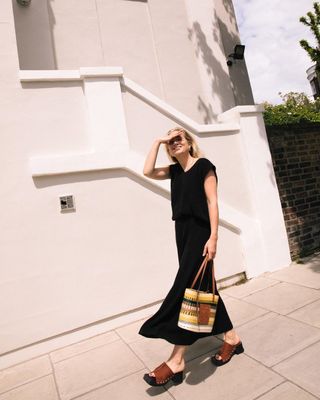 London Summer Shoe Trends: @lucywilliams02 wears a black draped jersey dress with wooden-sole clogs