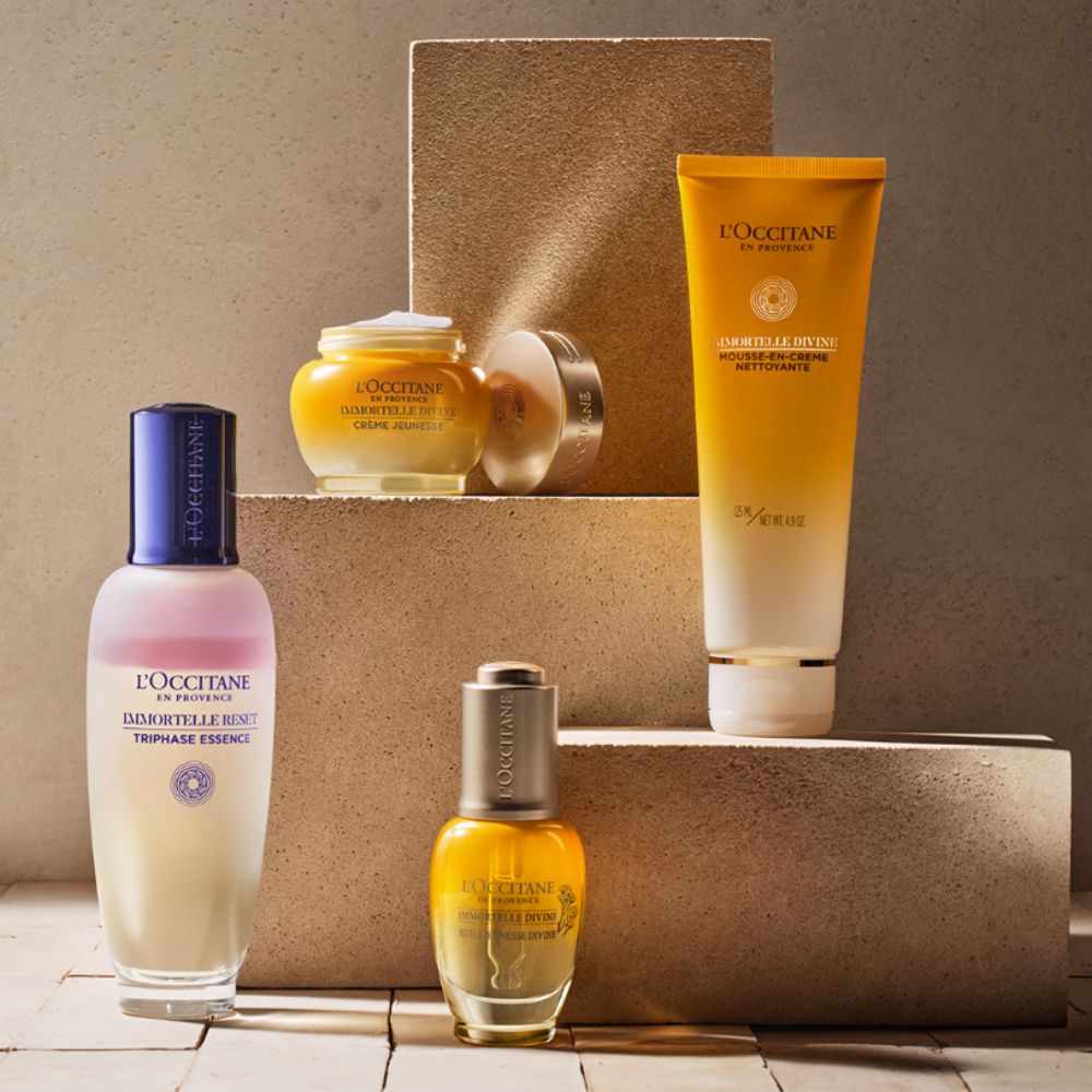 Photo of L'Occitane skincare products on stands and wood floor. 