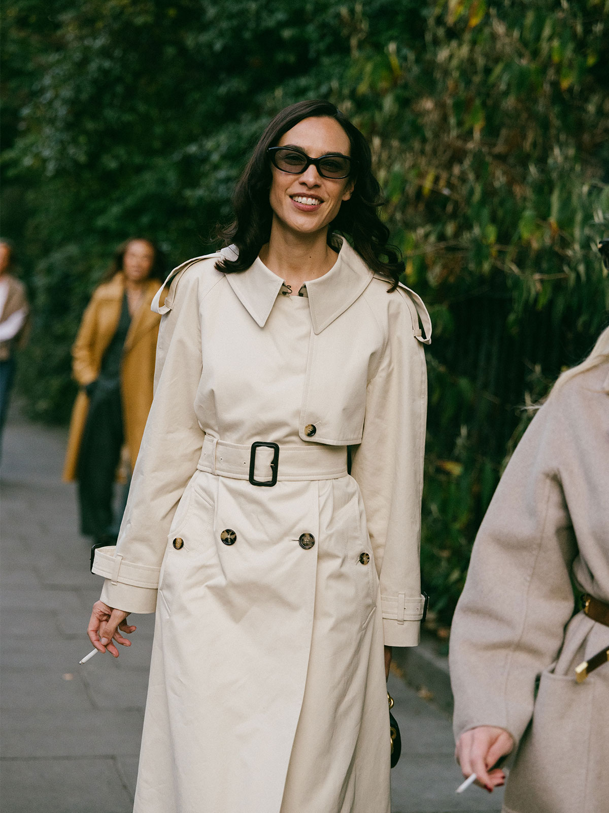 Woman wearing a light tan trench coat.